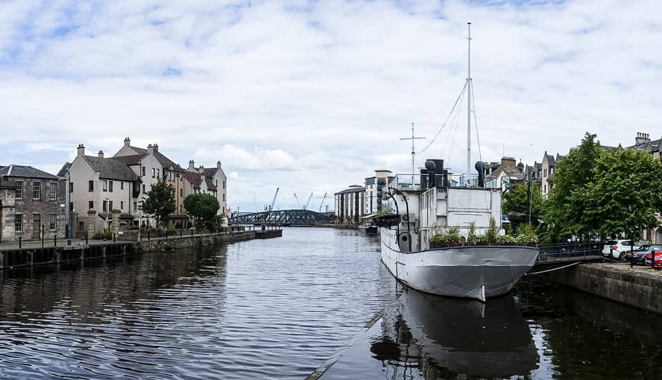 Un bateau est amarré sur une rivière dans la ville d’Édimbourg